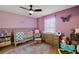 Bedroom with crib, dresser, rocking chair and a purple accent wall at 1017 Bluegrass Dr, Groveland, FL 34736