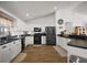 Kitchen with black appliances, white cabinets and a view to dining area at 1017 Bluegrass Dr, Groveland, FL 34736
