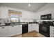 Bright kitchen features white cabinets, stainless steel appliances, and wood-look flooring at 1017 Bluegrass Dr, Groveland, FL 34736