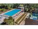Overhead view of community pool, tennis and shuffleboard courts, lounge areas, and pristine landscaping at 10301 Us Highway 27 # 63, Clermont, FL 34711