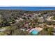 Community aerial view highlighting the lake, community pool, tennis courts, and cozy residential homes nestled in nature at 10301 Us Highway 27 # 63, Clermont, FL 34711