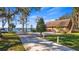 Lakeside home with a well-manicured lawn, long driveway, mature trees, and tranquil views of the water at 10301 Us Highway 27 # 63, Clermont, FL 34711