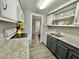 Galley kitchen featuring white appliances, granite countertops, and gray wood-look floors at 10301 Us Highway 27 # 63, Clermont, FL 34711