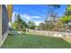 Spacious backyard featuring lush green grass, mature trees, and a fenced perimeter at 10640 Parkway Dr, Clermont, FL 34711