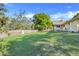 Large, grassy backyard with mature trees and a wooden fence at 10640 Parkway Dr, Clermont, FL 34711