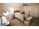 Bright bedroom with hardwood bed frame, ceiling fan, and neutral carpet at 10640 Parkway Dr, Clermont, FL 34711