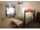 Bright bedroom with hardwood bed frame, ceiling fan, and neutral carpet at 10640 Parkway Dr, Clermont, FL 34711