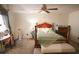 Bright bedroom with hardwood bed frame, ceiling fan, and neutral carpet at 10640 Parkway Dr, Clermont, FL 34711
