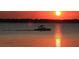 Scenic lake view featuring a wakeboard boat at sunset at 10640 Parkway Dr, Clermont, FL 34711