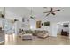 Bright living room features an L-shaped sofa, ceiling fans, tile flooring, and a view of the entryway at 10640 Parkway Dr, Clermont, FL 34711