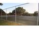 Outdoor tennis court surrounded by a chain-link fence and trees at 10640 Parkway Dr, Clermont, FL 34711