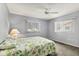 Bright bedroom with a floral comforter, windows, and neutral gray walls providing a calm atmosphere at 10683 Se 174Th Loop, Summerfield, FL 34491