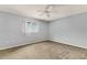 Cozy bedroom with neutral paint, carpet, a ceiling fan, and a window offering natural light at 10683 Se 174Th Loop, Summerfield, FL 34491