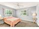 Light-filled bedroom with carpet, ceiling fan, windows, and neutral walls creating a welcoming space at 10683 Se 174Th Loop, Summerfield, FL 34491