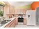 Well-lit kitchen featuring white appliances, plenty of cabinet space, and tile flooring at 10683 Se 174Th Loop, Summerfield, FL 34491