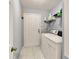 Functional laundry room with tile floor and overhead shelving for convenient storage solutions at 10683 Se 174Th Loop, Summerfield, FL 34491