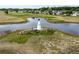 Picturesque lighthouse sits in the middle of a community pond with green space and homes nearby at 10683 Se 174Th Loop, Summerfield, FL 34491