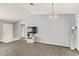 Open-concept living room with neutral walls, plush carpeting, and modern light fixture at 10683 Se 174Th Loop, Summerfield, FL 34491