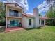 Rear exterior of a two-story home featuring a balcony, tile roof, and spacious yard at 1164 E Winged Foot Cir, Winter Springs, FL 32708