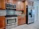 Modern kitchen featuring stainless steel appliances, wood cabinets, granite countertops, and tile backsplash at 1164 E Winged Foot Cir, Winter Springs, FL 32708