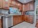 Charming kitchen features wood cabinets, stainless steel dishwasher, granite counters, and tiled backsplash at 1164 E Winged Foot Cir, Winter Springs, FL 32708