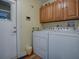Convenient laundry room includes a washer, dryer, overhead cabinets, and outdoor access at 1164 E Winged Foot Cir, Winter Springs, FL 32708