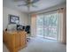 Home office with desk, computer setup and outdoor view through sliding glass doors at 1164 E Winged Foot Cir, Winter Springs, FL 32708