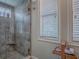 Modern shower stall featuring glass door, tiled walls, built in seat, and a window at 1164 E Winged Foot Cir, Winter Springs, FL 32708