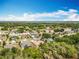 Residential area showcasing houses with green lawns and tree coverage, set against a blue sky and distant lake at 13546 Biscayne Grove Ln, Grand Island, FL 32735