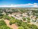 Expansive aerial view of a residential community, showcasing tree-lined streets on a bright day at 13546 Biscayne Grove Ln, Grand Island, FL 32735