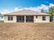 Back of house featuring a screened patio and expansive backyard space at 13546 Biscayne Grove Ln, Grand Island, FL 32735