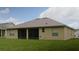 Home backyard featuring a large lawn and covered lanai at 13546 Biscayne Grove Ln, Grand Island, FL 32735