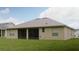 Expansive backyard featuring a screened patio, lush green grass, and a beige exterior home at 13546 Biscayne Grove Ln, Grand Island, FL 32735