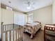 Cozy bedroom with wood-look flooring, ceiling fan, and neutral walls at 13546 Biscayne Grove Ln, Grand Island, FL 32735