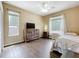 Bedroom with wood-look floors, two windows, a comfortable bed, and a TV dresser, offering a cozy and functional space at 13546 Biscayne Grove Ln, Grand Island, FL 32735