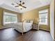Bedroom featuring wood-look floors, a comfortable bed, and a tray ceiling, creating a serene retreat at 13546 Biscayne Grove Ln, Grand Island, FL 32735