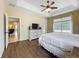 Bedroom with wood-look floors, a comfortable bed, and a large window, creating a cozy and inviting atmosphere at 13546 Biscayne Grove Ln, Grand Island, FL 32735