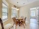 Charming breakfast nook featuring a round wooden table, traditional chairs, and natural light from the adjacent window at 13546 Biscayne Grove Ln, Grand Island, FL 32735