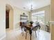 Elegant dining room features a stylish chandelier, large window, and a wooden dining table with ornate chairs at 13546 Biscayne Grove Ln, Grand Island, FL 32735