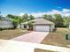 Attractive single-story house with a brick driveway and an attached two-car garage, perfect for Gathering living at 13546 Biscayne Grove Ln, Grand Island, FL 32735