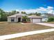 Charming single-story home with a well-maintained lawn and a two-car garage on a sunny day at 13546 Biscayne Grove Ln, Grand Island, FL 32735