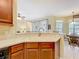 Kitchen area with a white sink and wood cabinets that opens to the eat-in dining area at 13546 Biscayne Grove Ln, Grand Island, FL 32735