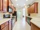 Well-lit kitchen featuring wood cabinets, modern appliances, and a white tile floor at 13546 Biscayne Grove Ln, Grand Island, FL 32735