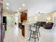 Open kitchen featuring bar seating, tile flooring, and views into the living room, offering a great flow for entertaining at 13546 Biscayne Grove Ln, Grand Island, FL 32735