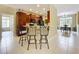 Kitchen with bar seating and views of the dining area, featuring dark cabinets, ample counter space, and modern appliances at 13546 Biscayne Grove Ln, Grand Island, FL 32735