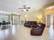Bright and airy living room featuring tile floors, a leather sofa set, and views into the dining area at 13546 Biscayne Grove Ln, Grand Island, FL 32735