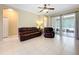 Open living room featuring tile floors, a comfortable leather sofa and chair set, and sliding glass doors to the outdoor patio at 13546 Biscayne Grove Ln, Grand Island, FL 32735