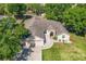 Aerial view showcasing the home's roofline, driveway, and meticulously maintained surrounding landscaping at 14421 Pine Cone Trl, Clermont, FL 34711