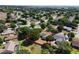 A home and its surrounding neighborhood are seen in an aerial shot filled with lush trees and manicured lawns at 14421 Pine Cone Trl, Clermont, FL 34711