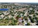 Drone shot of the home in its surrounding neighborhood with lush greenery and serene lake views nearby at 14421 Pine Cone Trl, Clermont, FL 34711